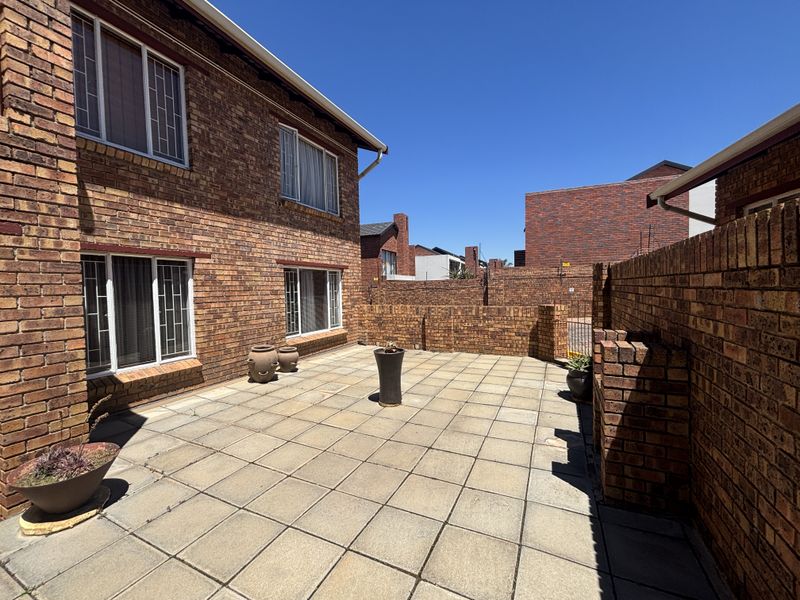 A private rear courtyard featuring face brick walls and paved flooring, providing a low-maintenance outdoor space for the townhouse.