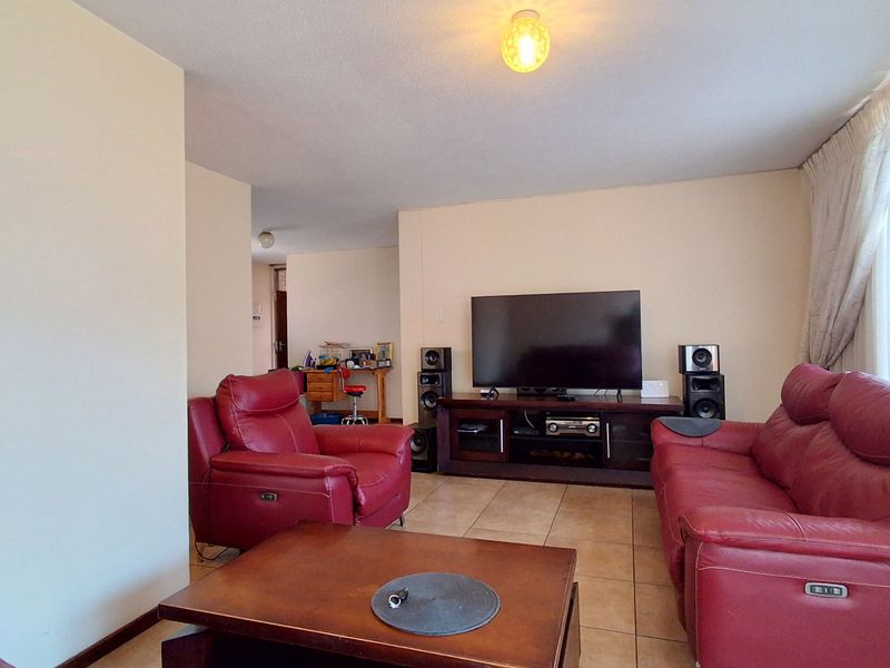 A spacious living room featuring neutral walls and tiled flooring, providing a comfortable and functional area for relaxation.