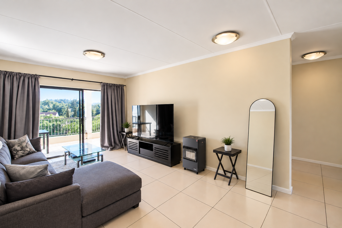 Spacious living room featuring neutral tiled flooring, ceiling lighting, and direct access to a private balcony through large sliding glass doors.