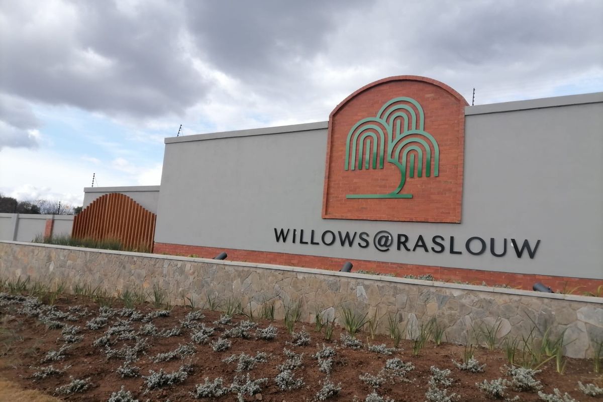 The entrance signage and perimeter wall for the Willows at Raslouw residential estate, featuring stone cladding and well-maintained landscaping.