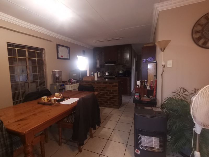 Open plan living and kitchen area featuring a brick breakfast bar, tiled flooring, and built-in cabinetry.