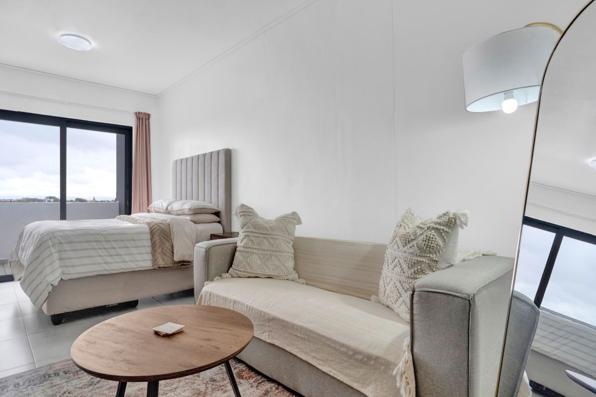 A bright bedroom featuring tiled flooring and a sliding glass door providing access to an outdoor area.