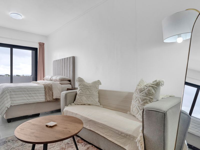 A bright bedroom featuring tiled flooring and a sliding glass door providing access to an outdoor area.