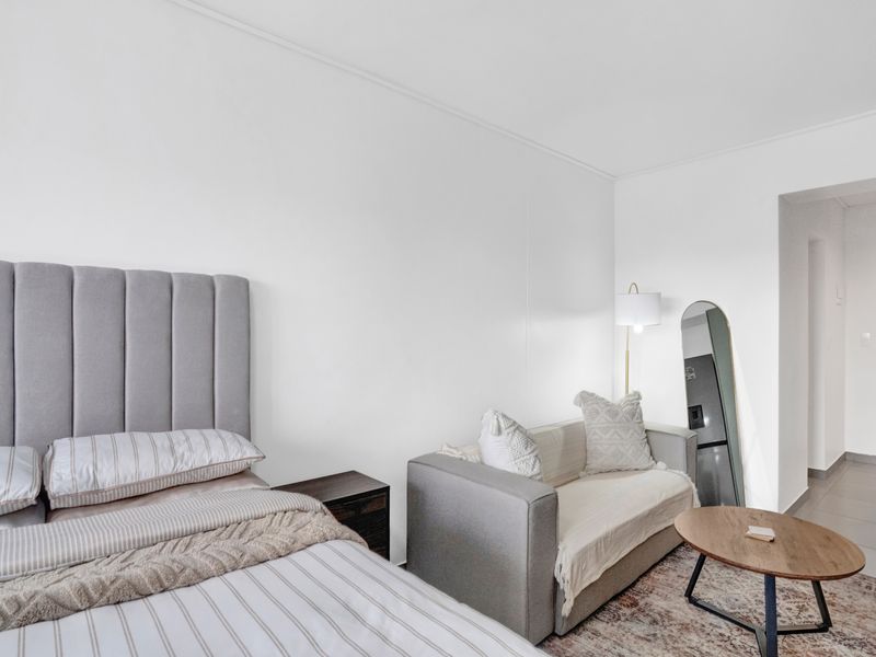 A well-maintained bedroom featuring neutral wall finishes and tiled flooring, providing a clean and comfortable living space.