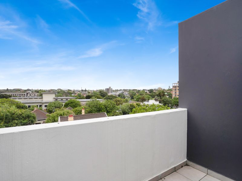 A private balcony featuring tiled flooring and a solid balustrade, offering expansive elevated views over the surrounding neighbourhood.