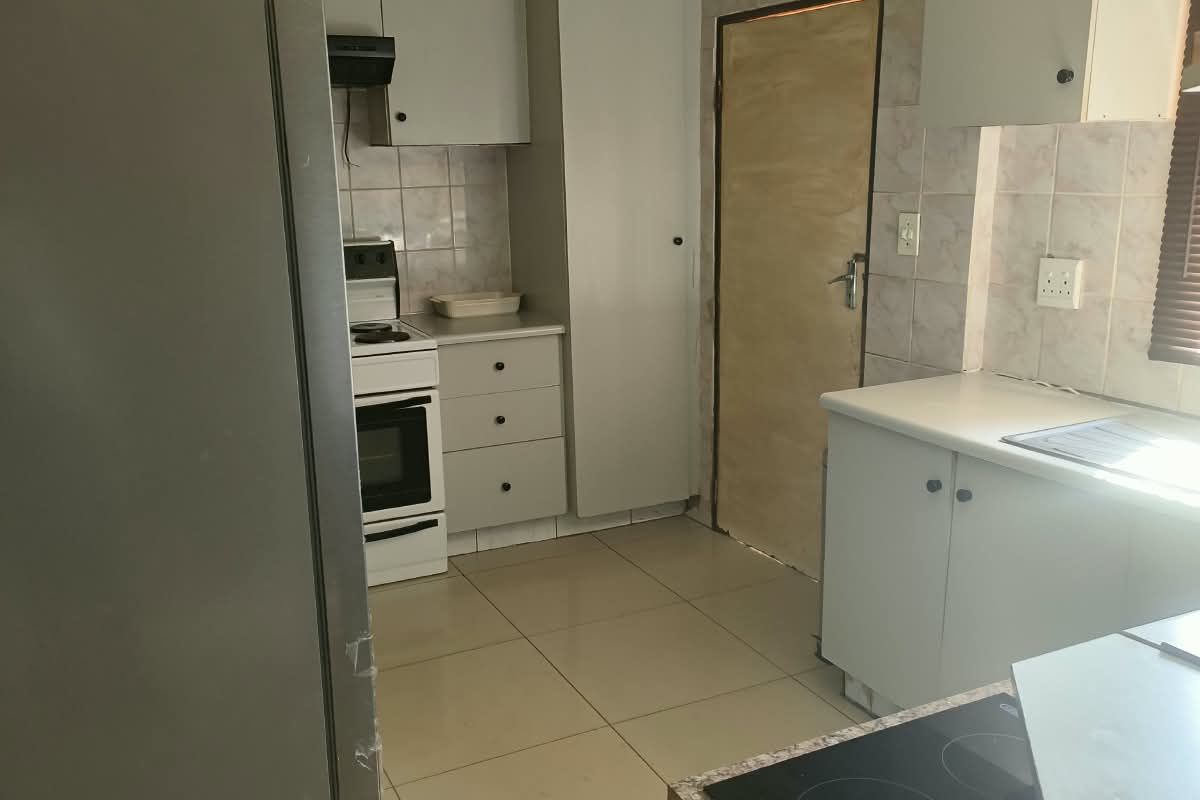 A dated kitchen featuring tiled flooring, built-in cabinetry, and an electric stove, offering significant potential for modernization and renovation.