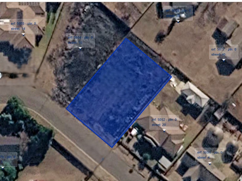 An aerial satellite view showing the vacant residential plot highlighted in blue within an established suburban neighborhood.