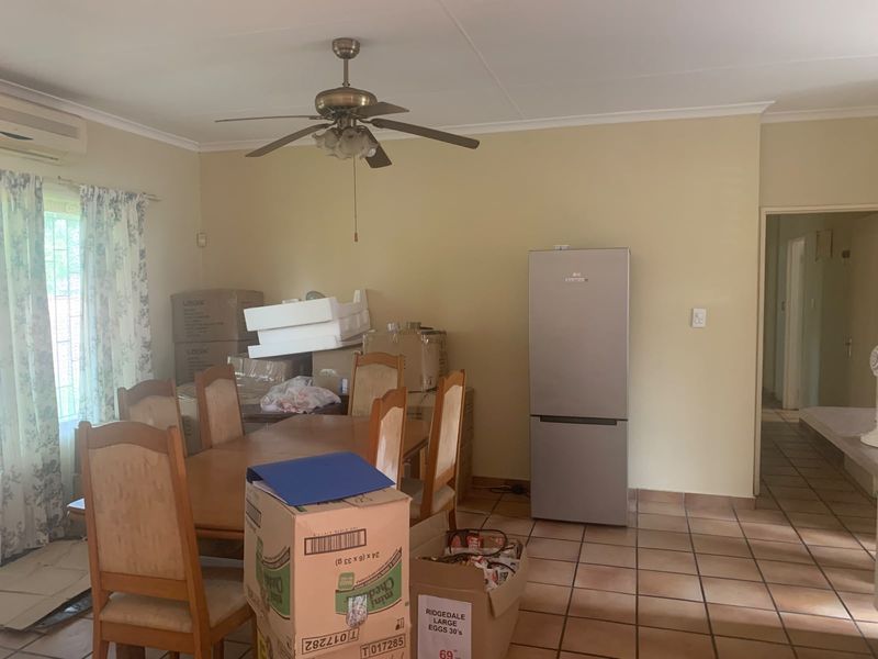 Dining area featuring tiled flooring, a ceiling fan, and an installed air conditioning unit.
