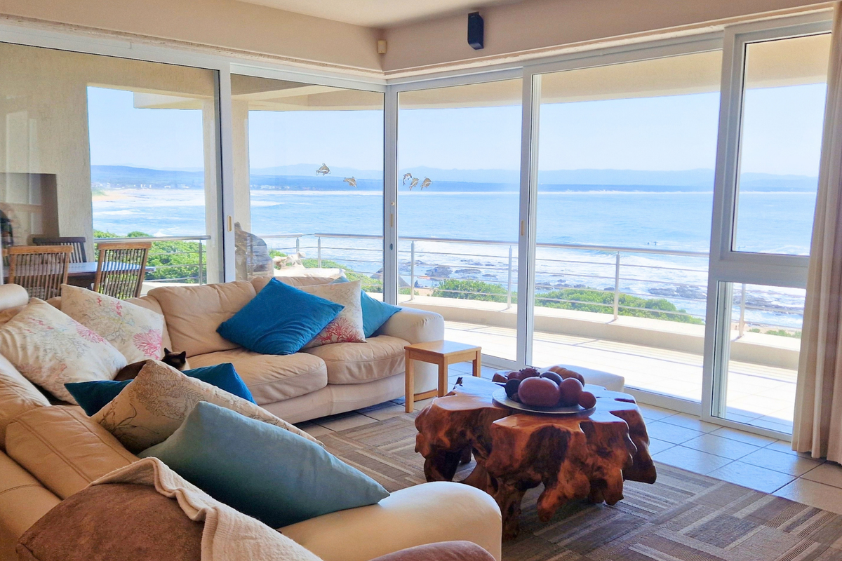 Spacious living room featuring expansive sliding glass doors that offer panoramic ocean views and direct access to a private balcony.