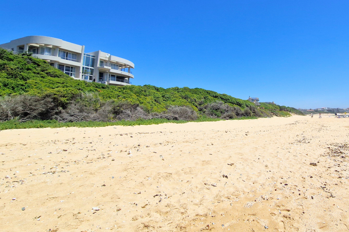 A scenic view of the property exterior situated on a coastal dune overlooking the sandy beach.