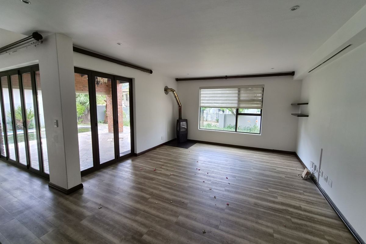 Spacious living area featuring laminate flooring, a built-in wood-burning fireplace, and large sliding glass doors providing direct access to the outdoor patio.