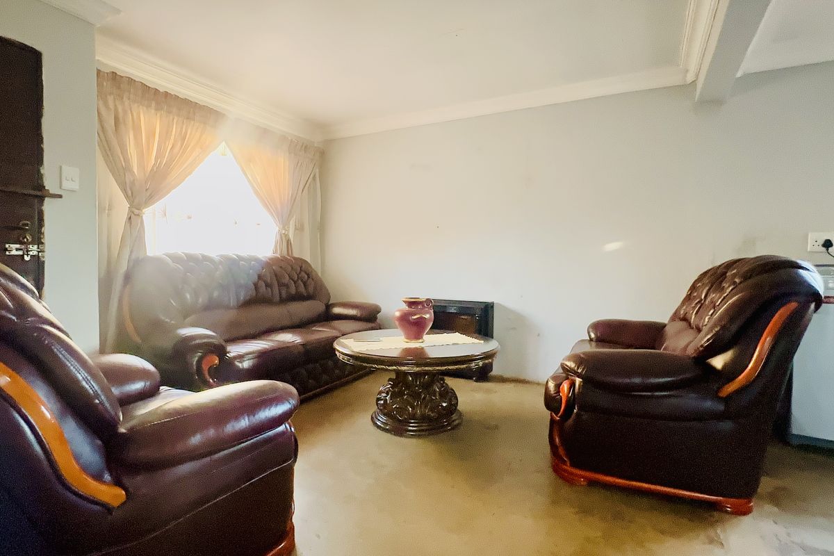 A living room featuring neutral walls, coving, and carpeted flooring, offering a blank canvas for potential interior updates and modernization.