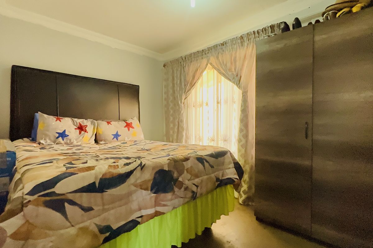 A standard bedroom featuring a built-in wardrobe and decorative ceiling cornice, providing a functional sleeping space.