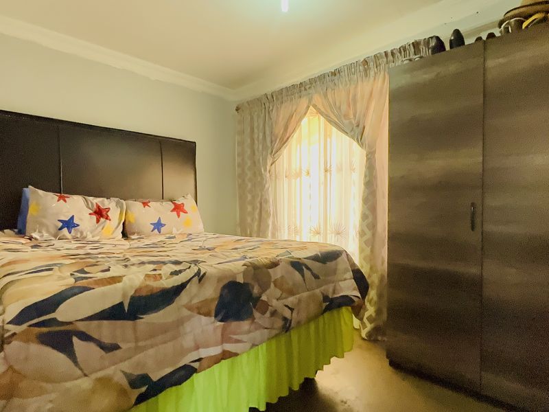 A standard bedroom featuring a built-in wardrobe and decorative ceiling cornice, providing a functional sleeping space.
