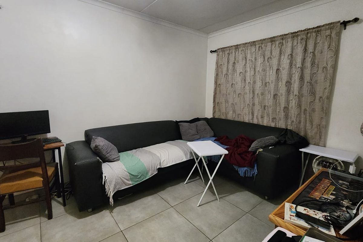 A living room area featuring tiled flooring and neutral wall finishes, providing a functional space for relaxation.