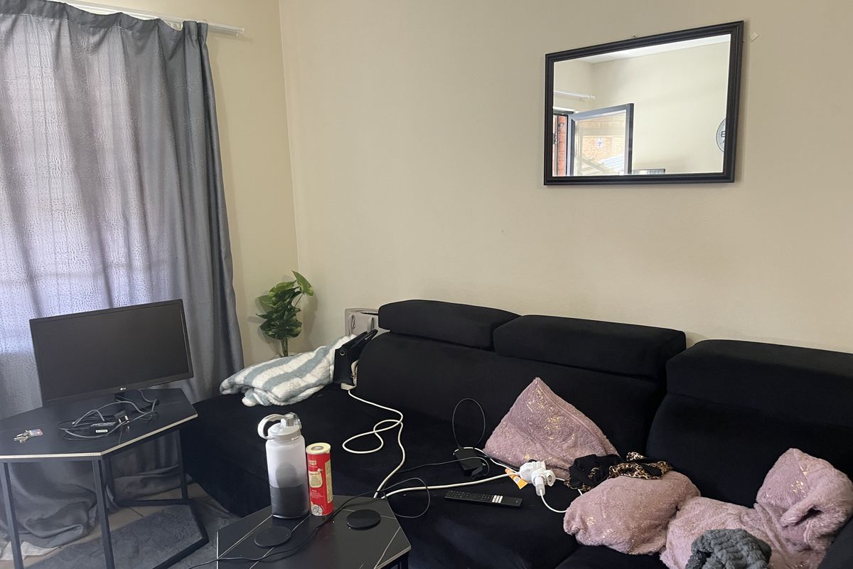 A living room area featuring neutral wall paint and a curtain rail, providing a functional space for relaxation.