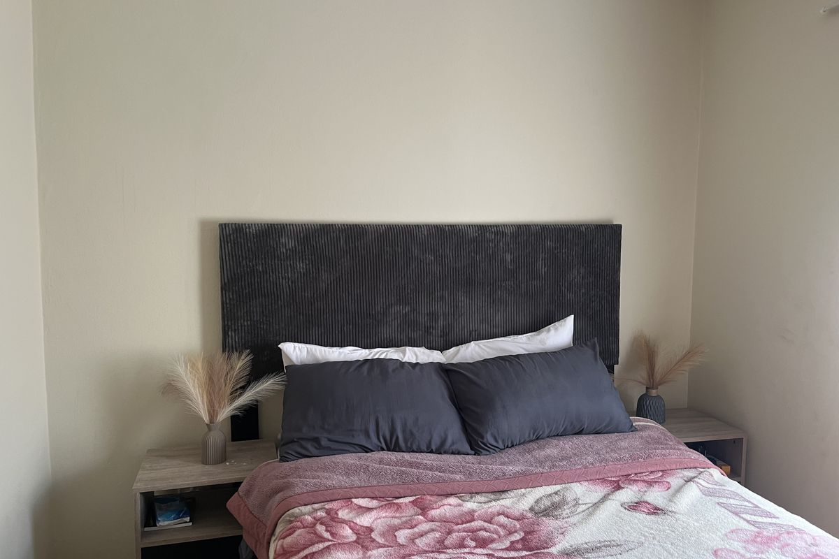 A simple bedroom featuring neutral wall finishes and a functional layout, providing a comfortable space for rest.