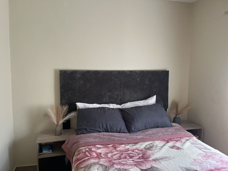 A simple bedroom featuring neutral wall finishes and a functional layout, providing a comfortable space for rest.