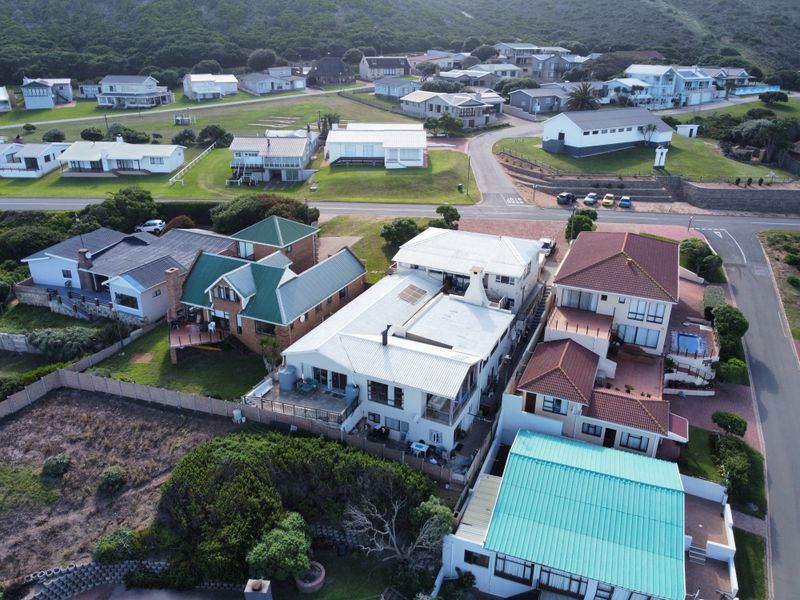 Aerial view of the residential property and surrounding neighbourhood, showcasing the roof structure, layout, and coastal estate setting.