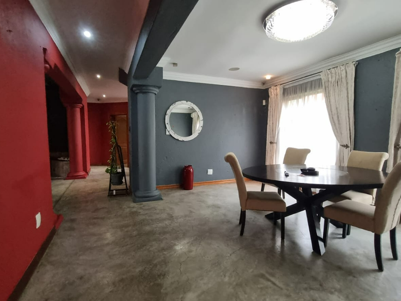 Dining area featuring polished concrete floors, decorative columns, and crown molding, offering a distinct architectural style with potential for modern updates.
