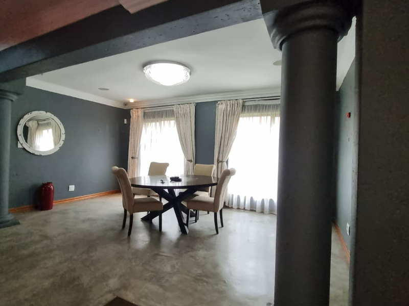 Spacious dining area featuring polished concrete floors, structural columns, and large windows with natural light, creating an open and modern atmosphere.