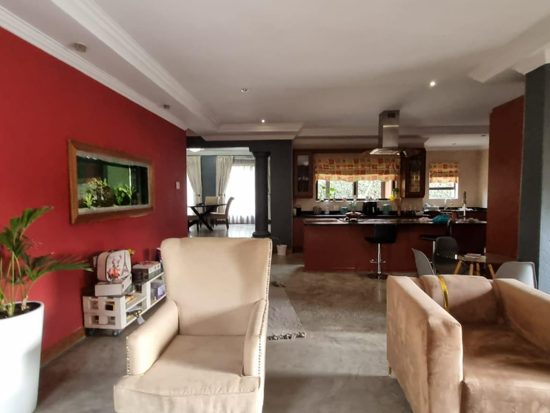 Spacious open-plan living area featuring a kitchen with island, extractor fan, and a unique built-in wall aquarium, finished with crown molding and recessed lighting.