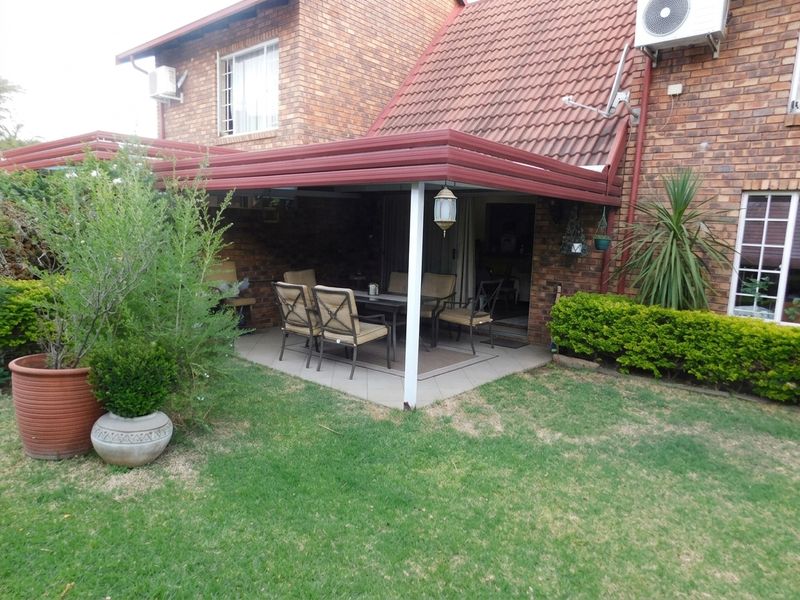 A covered patio area featuring tiled flooring and brick exterior walls, providing a functional outdoor space for relaxation and entertaining.