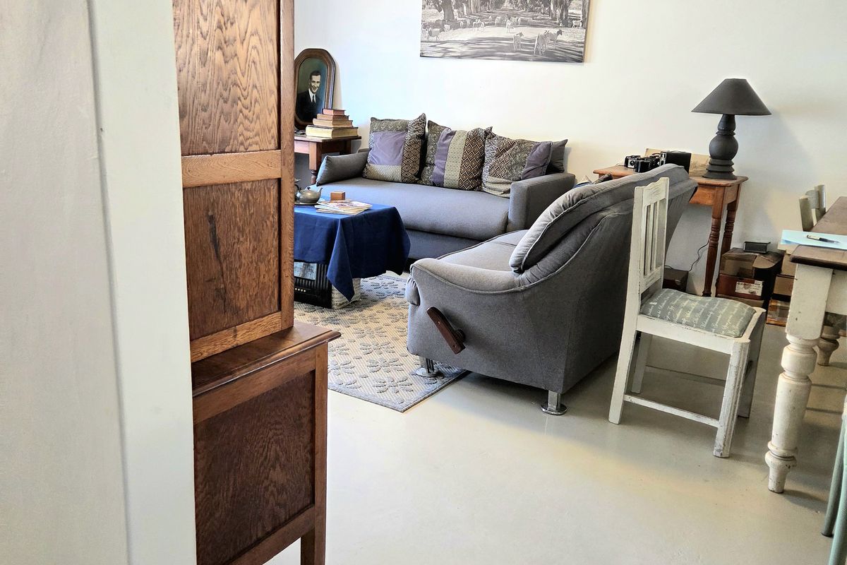 A living room area featuring a painted concrete floor and a tongue and groove ceiling, offering a neutral base for interior design.