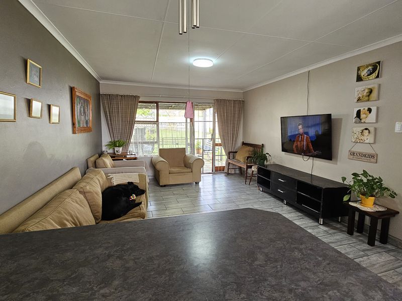Open plan living area featuring tiled flooring, a breakfast bar, and sliding glass doors leading to the outdoor patio space.