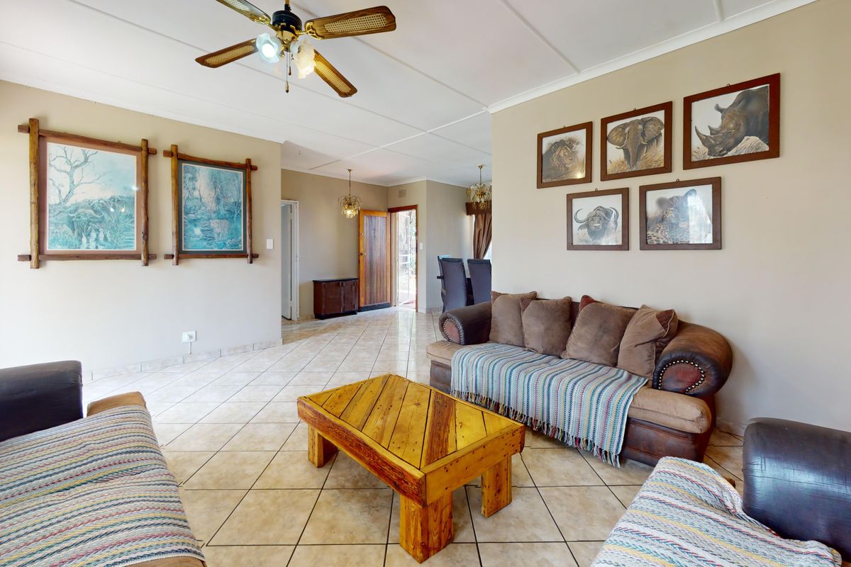 Spacious living area featuring neutral wall tones, tiled flooring, and a ceiling fan, providing a comfortable and functional space for relaxation.