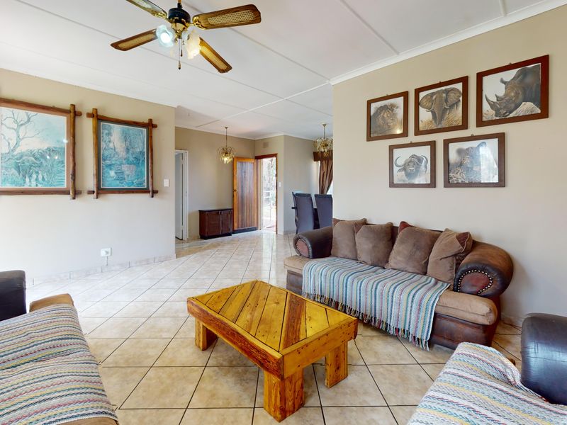 Spacious living area featuring neutral wall tones, tiled flooring, and a ceiling fan, providing a comfortable and functional space for relaxation.