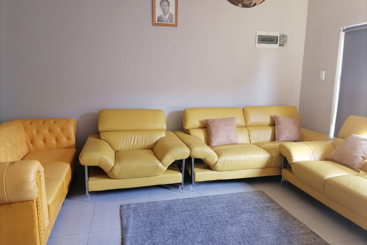 A living room featuring neutral wall tones and tiled flooring, equipped with a wall-mounted electrical distribution board.