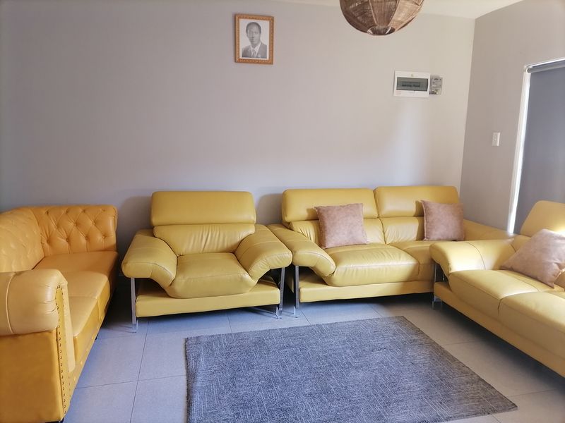 A living room featuring neutral wall tones and tiled flooring, equipped with a wall-mounted electrical distribution board.