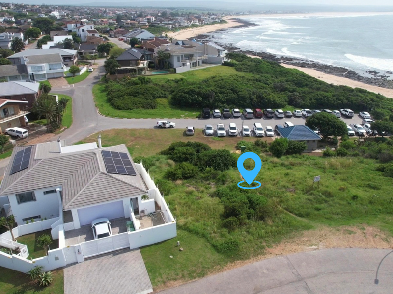Aerial view of a vacant residential plot situated in a prime coastal location near the beach and local amenities.