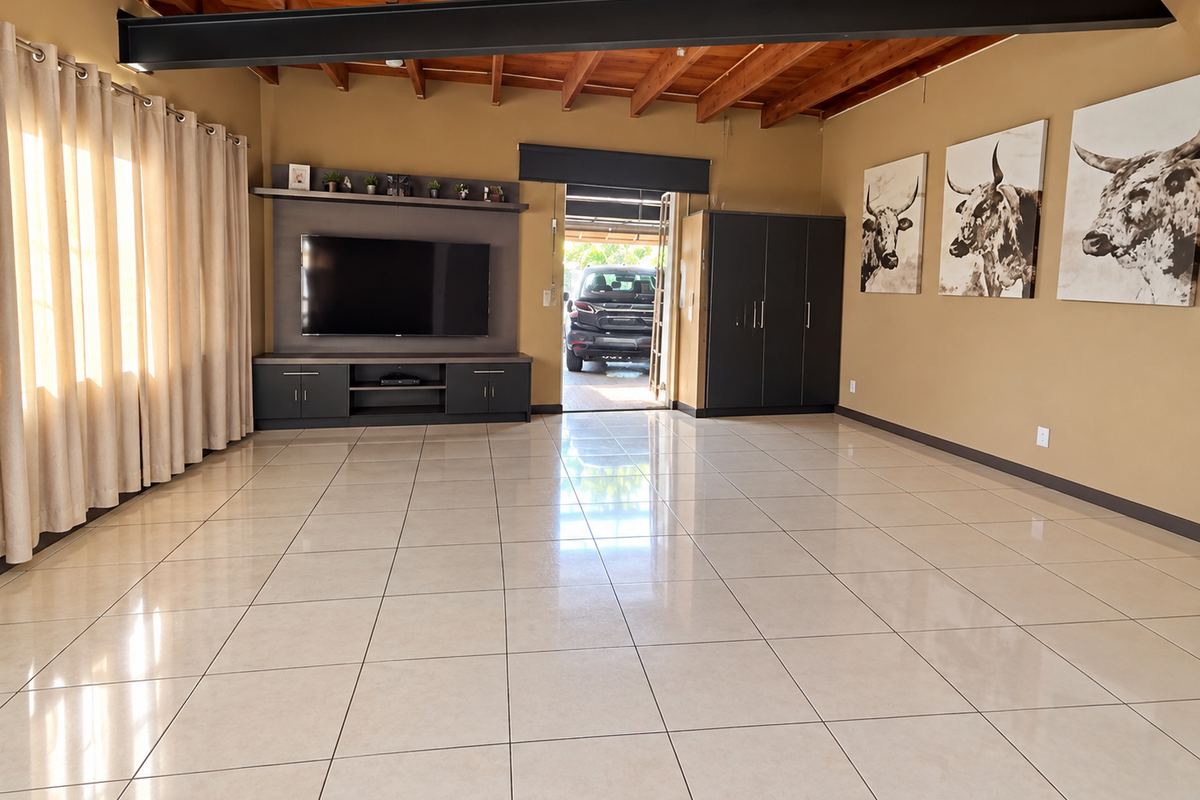 Spacious living area featuring high exposed timber beam ceilings, polished tile flooring, and custom built-in cabinetry for media and storage.