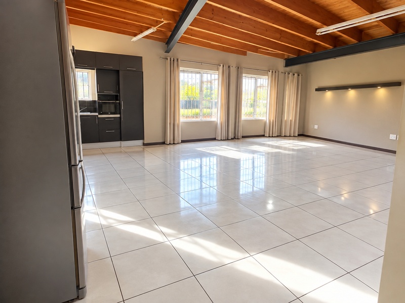 Spacious open-plan living area featuring high exposed timber beam ceilings, polished tile flooring, and a modern built-in kitchen unit with integrated oven.