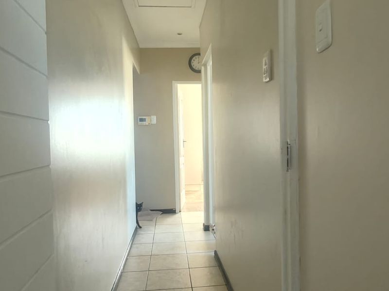 A functional hallway featuring tiled flooring and neutral wall finishes, providing access to adjacent rooms within the townhouse.