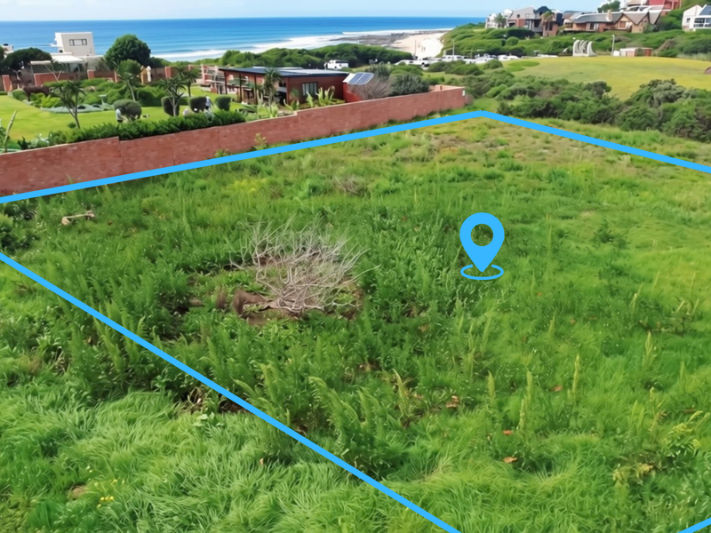 Aerial view of a vacant residential plot featuring coastal views and established boundary walls in a desirable neighborhood.