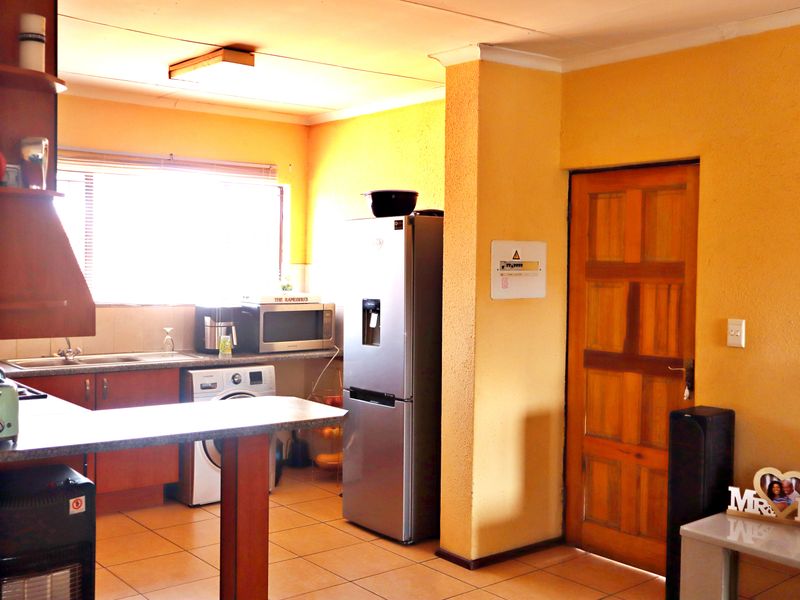 A functional kitchen area featuring tiled flooring, built-in cabinetry, and a breakfast counter, offering a practical layout for daily use.