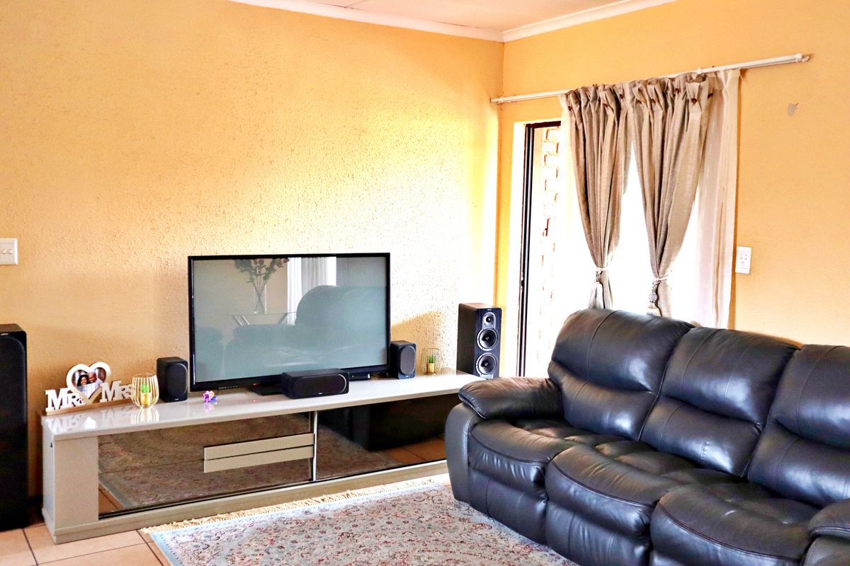 A living room featuring tiled flooring and a sliding glass door with access to an outdoor area.