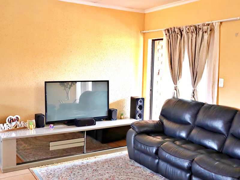 A living room featuring tiled flooring and a sliding glass door with access to an outdoor area.