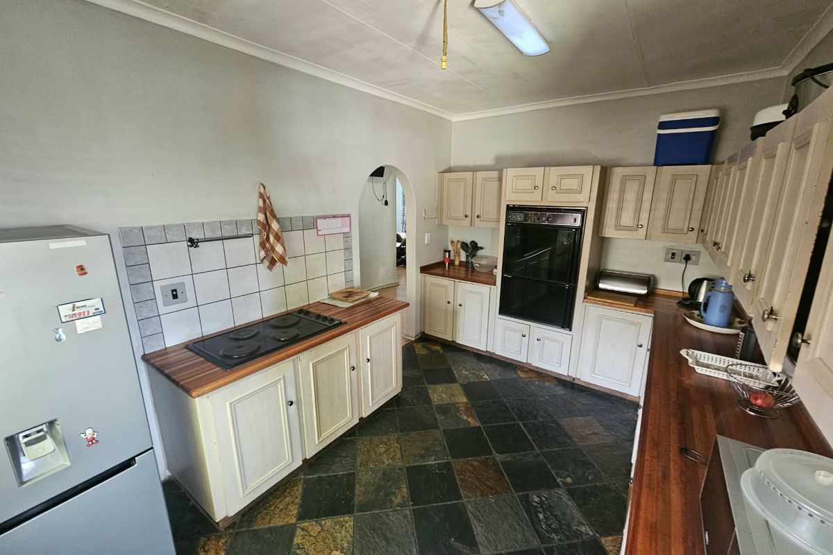A functional kitchen featuring wooden countertops, built-in cabinetry, an integrated oven, and a classic slate tile floor.