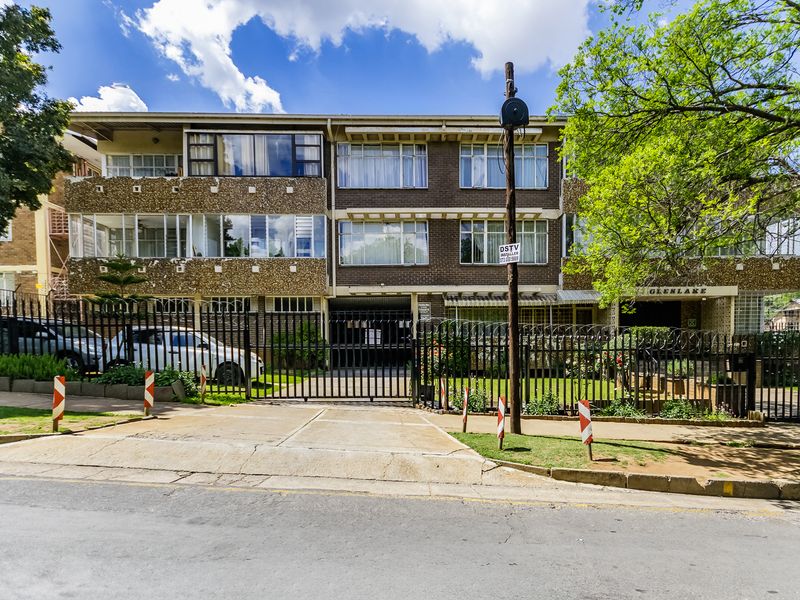 Front elevation of the Glenlake apartment complex, featuring a brick facade, secure gated entrance, and enclosed balcony units.