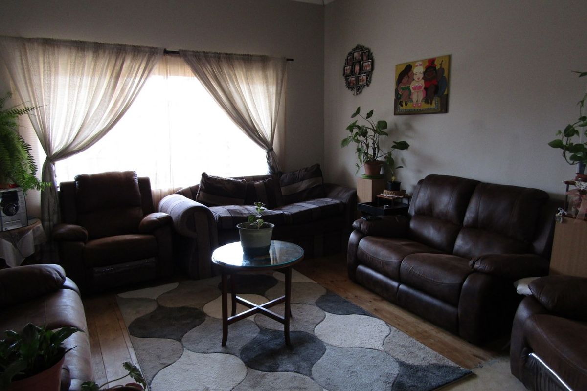 A comfortable living room featuring hardwood flooring and crown molding, providing a warm and inviting space for relaxation.