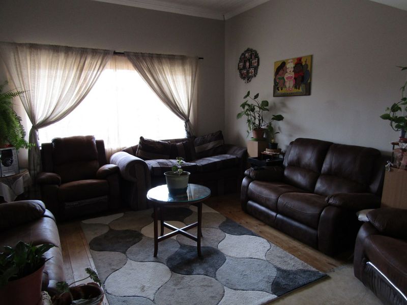 A comfortable living room featuring hardwood flooring and crown molding, providing a warm and inviting space for relaxation.