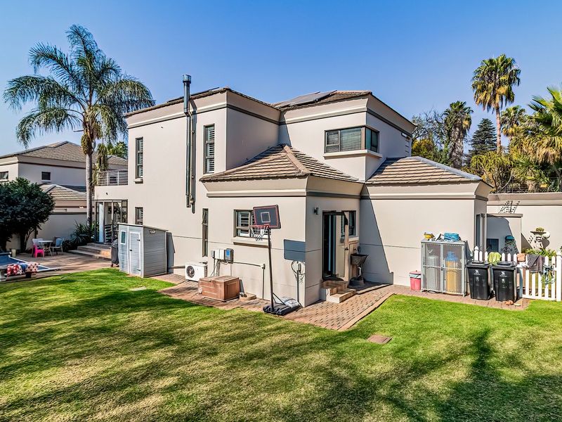 Rear view of the cluster home featuring a private swimming pool, paved patio area, well-maintained lawn, and secure perimeter walling.