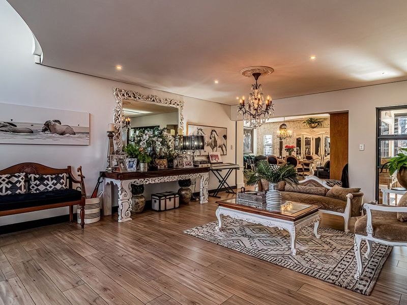 Spacious living area featuring wood-look laminate flooring, recessed lighting, and a stone-clad feature wall, offering a bright and inviting atmosphere.