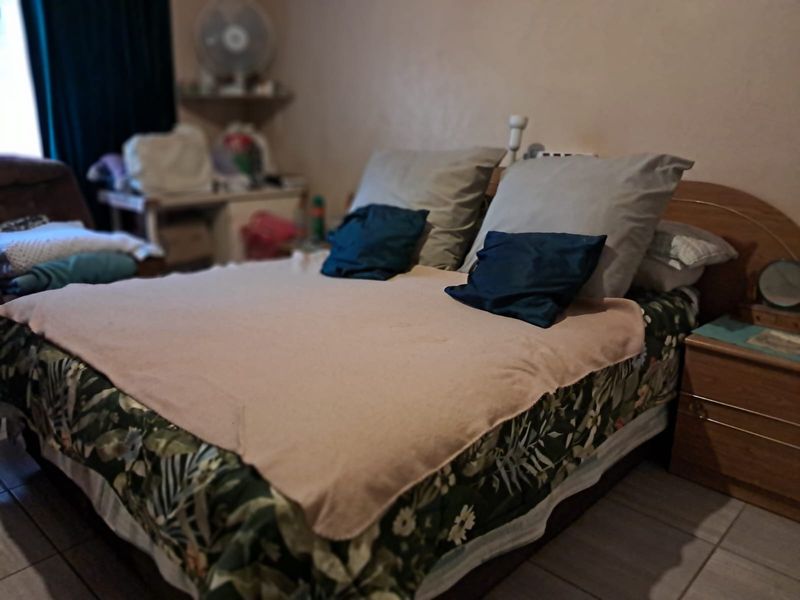 A bedroom featuring tiled flooring and neutral wall finishes, providing a functional space for rest.