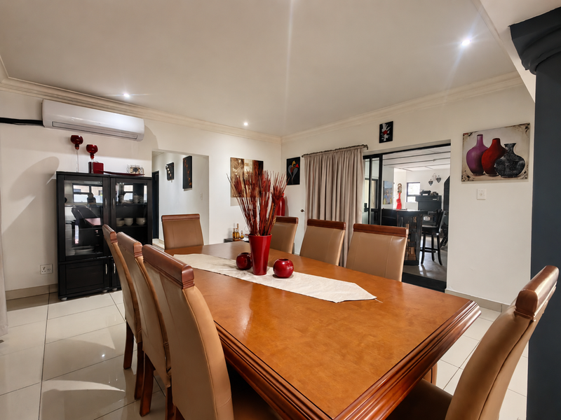 A well-maintained dining room featuring tiled flooring, recessed lighting, and a split-system air conditioner, with an open flow to adjacent living spaces.