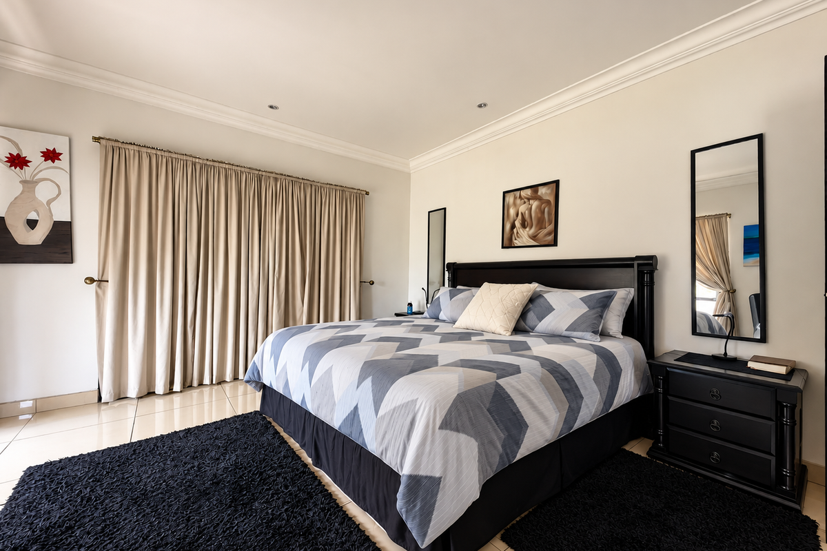 A well-maintained bedroom featuring neutral walls, crown molding, recessed lighting, and tiled flooring, providing a clean and comfortable living space.